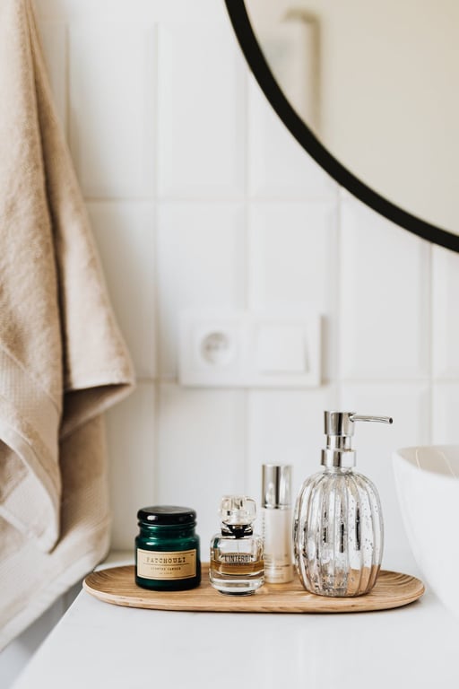 Composition de savon liquide, de parfum et de produits de soins de la peau placée sur une assiette en bambou dans une salle de bains moderne